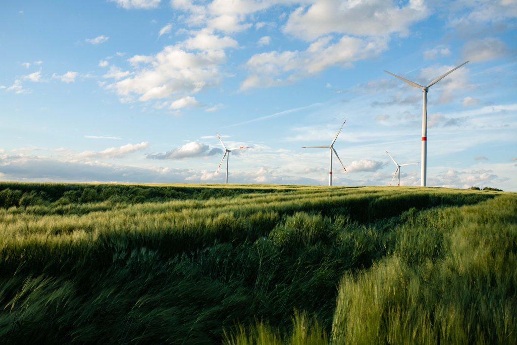 otimizado beautiful grassy field with windmills distance blue sky